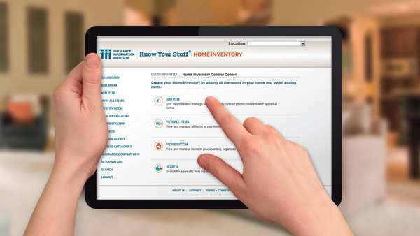 Person holding up tablet with home inventory software displayed