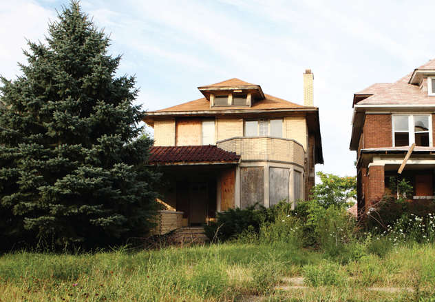 dilapidated house with overgrown yard