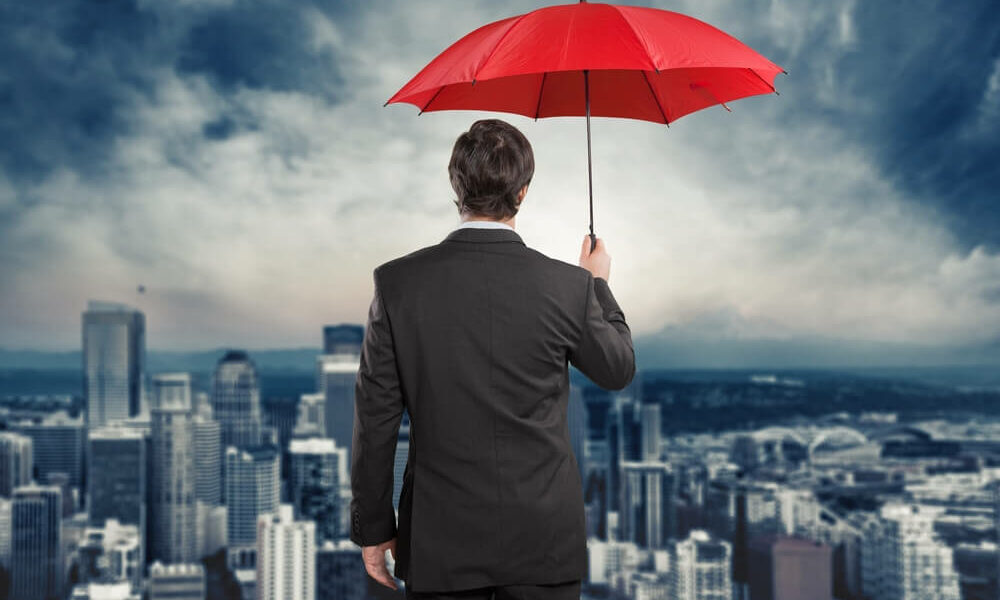 Main in suit with umbrella overlooking city