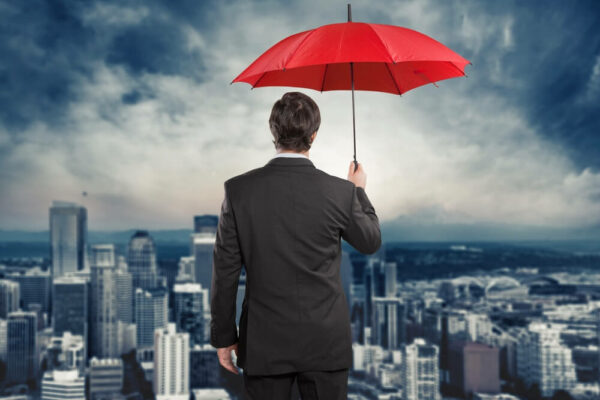 Main in suit with umbrella overlooking city